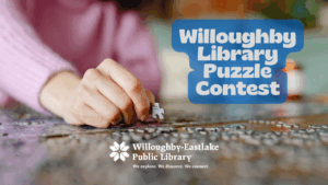 Text that says Willoughby Library Puzzle Contest over a picture of a hand putting a piece into a puzzle